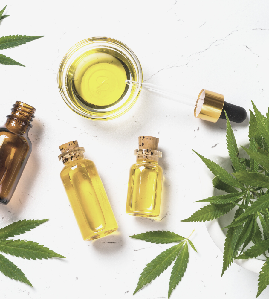 Cannabis e ansia: olio di canapa in boccette trasparenti e foglie di cannabis